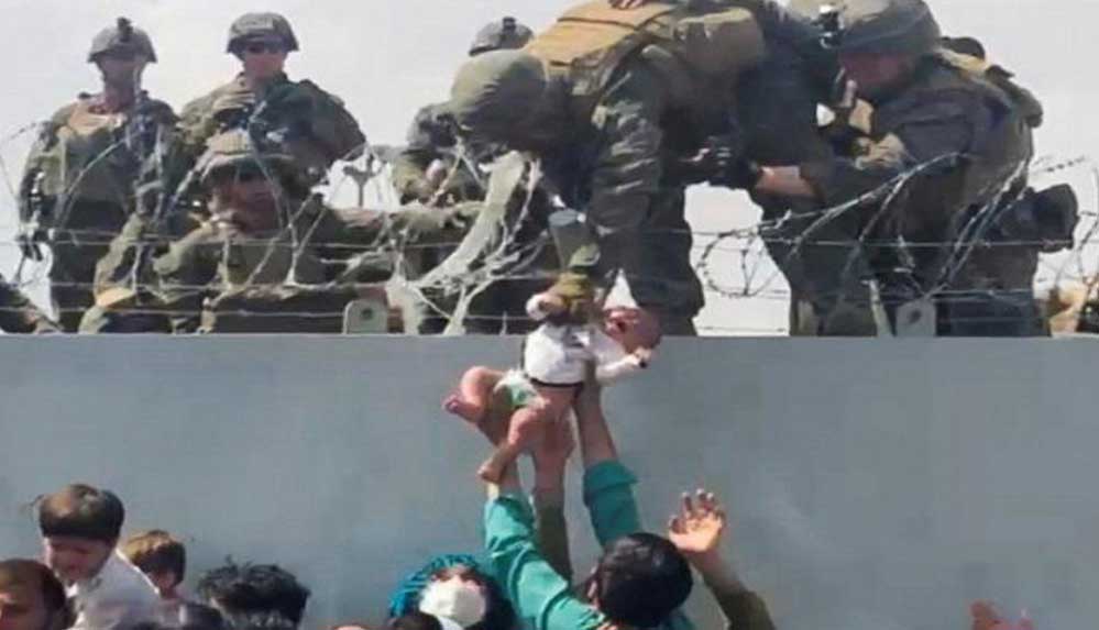 Kabil'deki havalimanında duvarın üzerinden ABD askerlerine verilirken görüntülenen bebek ailesine kavuştu