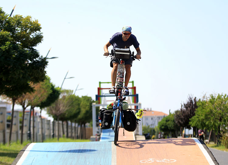 İtalyan bisikletçi, "uzun bisikleti" ve yolda bulduğu köpeği ile dünya turunda