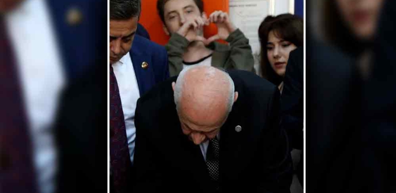 Günün karesi: Bir genç Bahçeli oy kullanırken arkasından kalp işareti yaptı