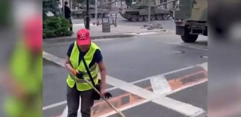 Rusya’da tanklar sokakta gezerken, işçi temizlik yapmaya devam etti